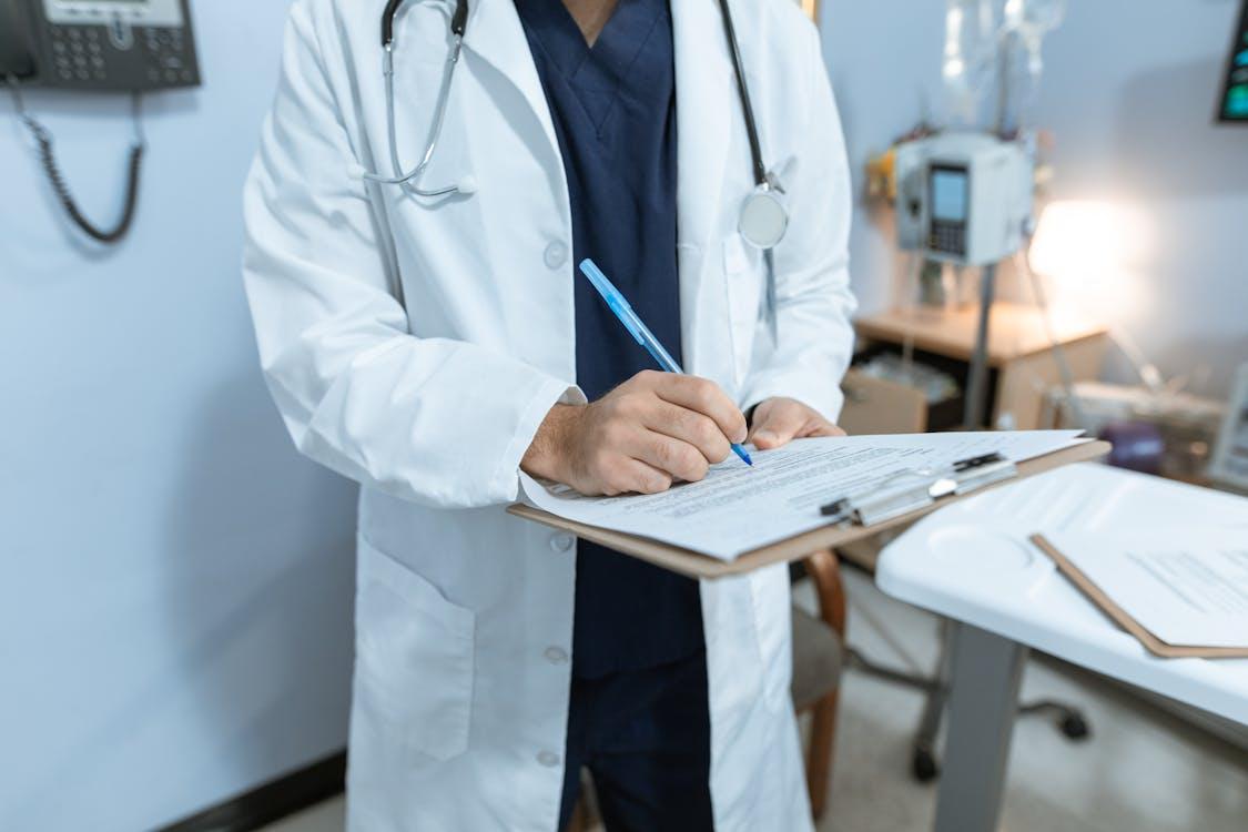 cropped photo of a doctor signing a medical leave note