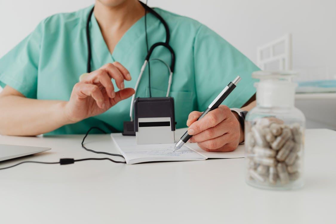 a doctor signing and stamping a leave note