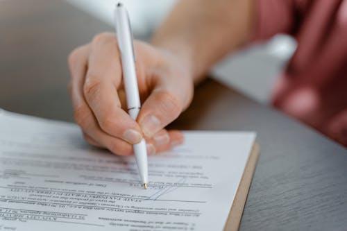Close-up of a person signing a document