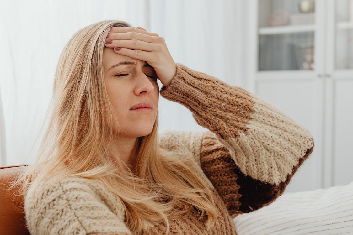 a person with migraine pain holding their head