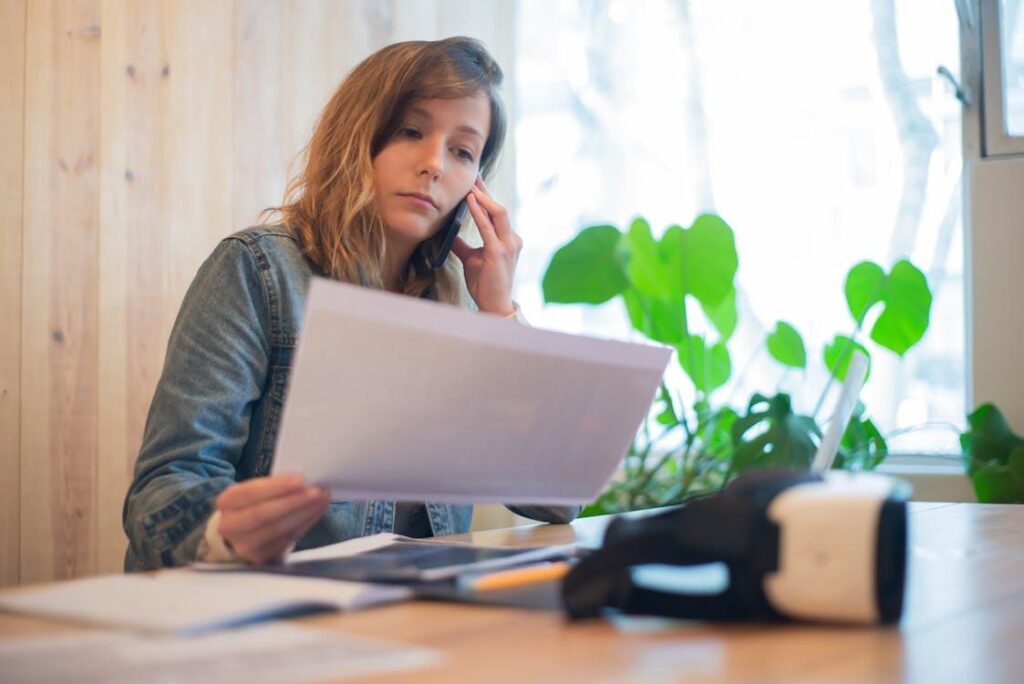 A photo showing a woman using a phone at a desk