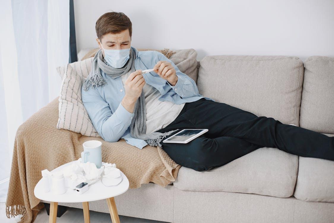 a sick man lying on the couch
