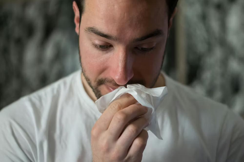A man wiping his nose with a tissue 