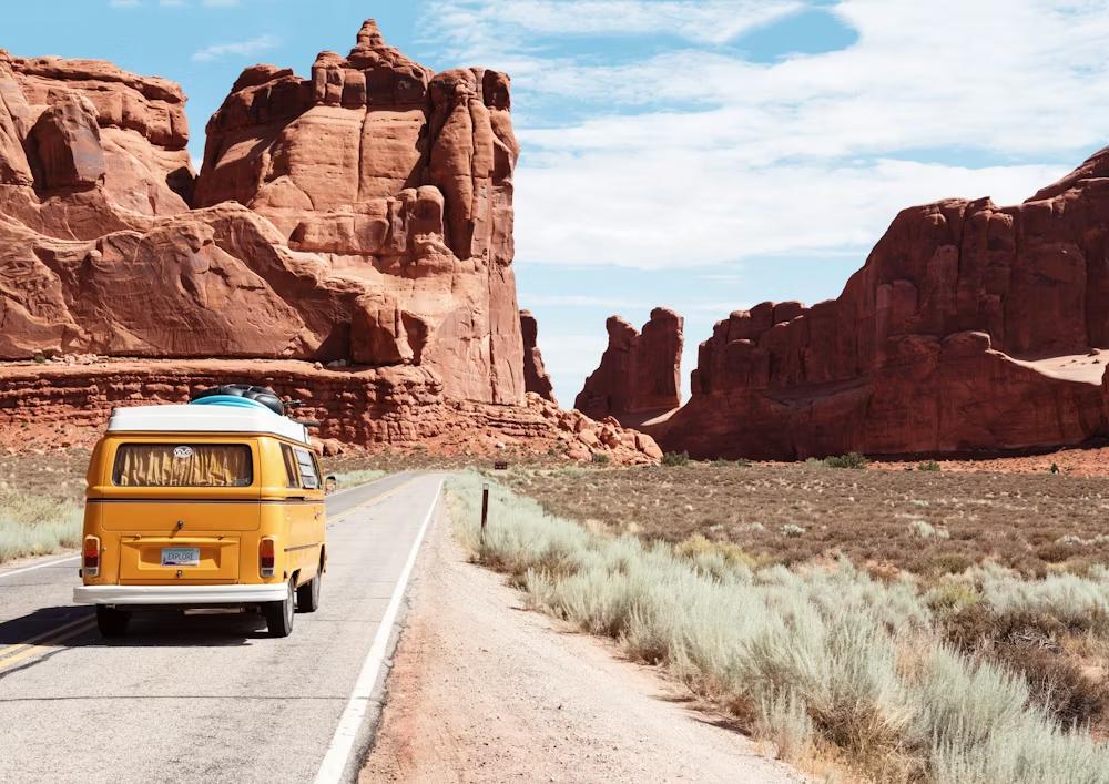 A yellow car on the road in a canyon