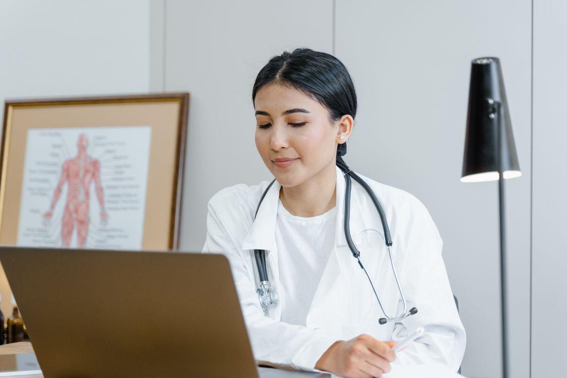 a doctor looking at a screen and talking to a patient.