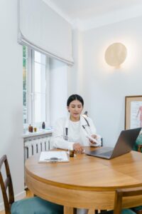 a woman in a lab coat at her home office.