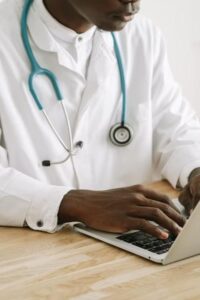 a doctor typing on their laptop.
