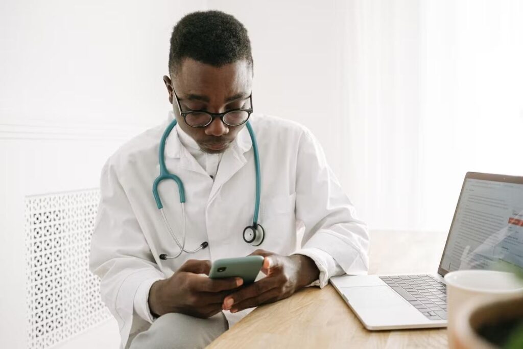 a doctor sitting in his office and using his phone.