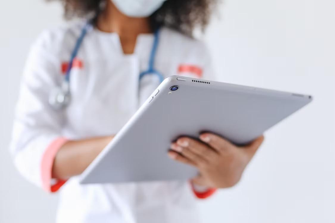 a doctor in a lab coat taking notes.