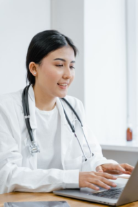 a doctor taking notes on her laptop.