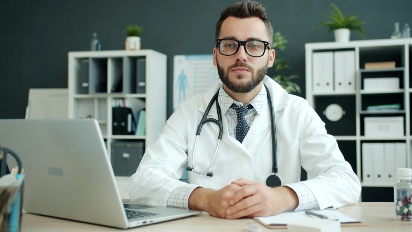 A doctor at his desk using a laptop