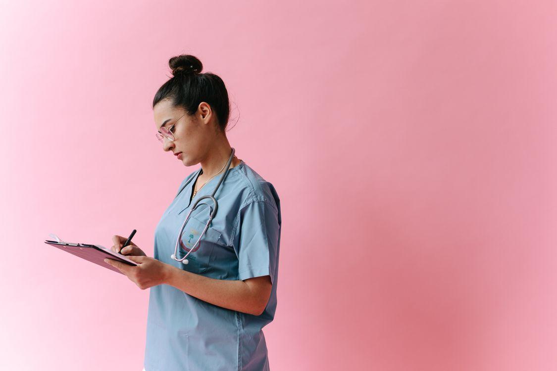 A doctor writing down a note for a person.