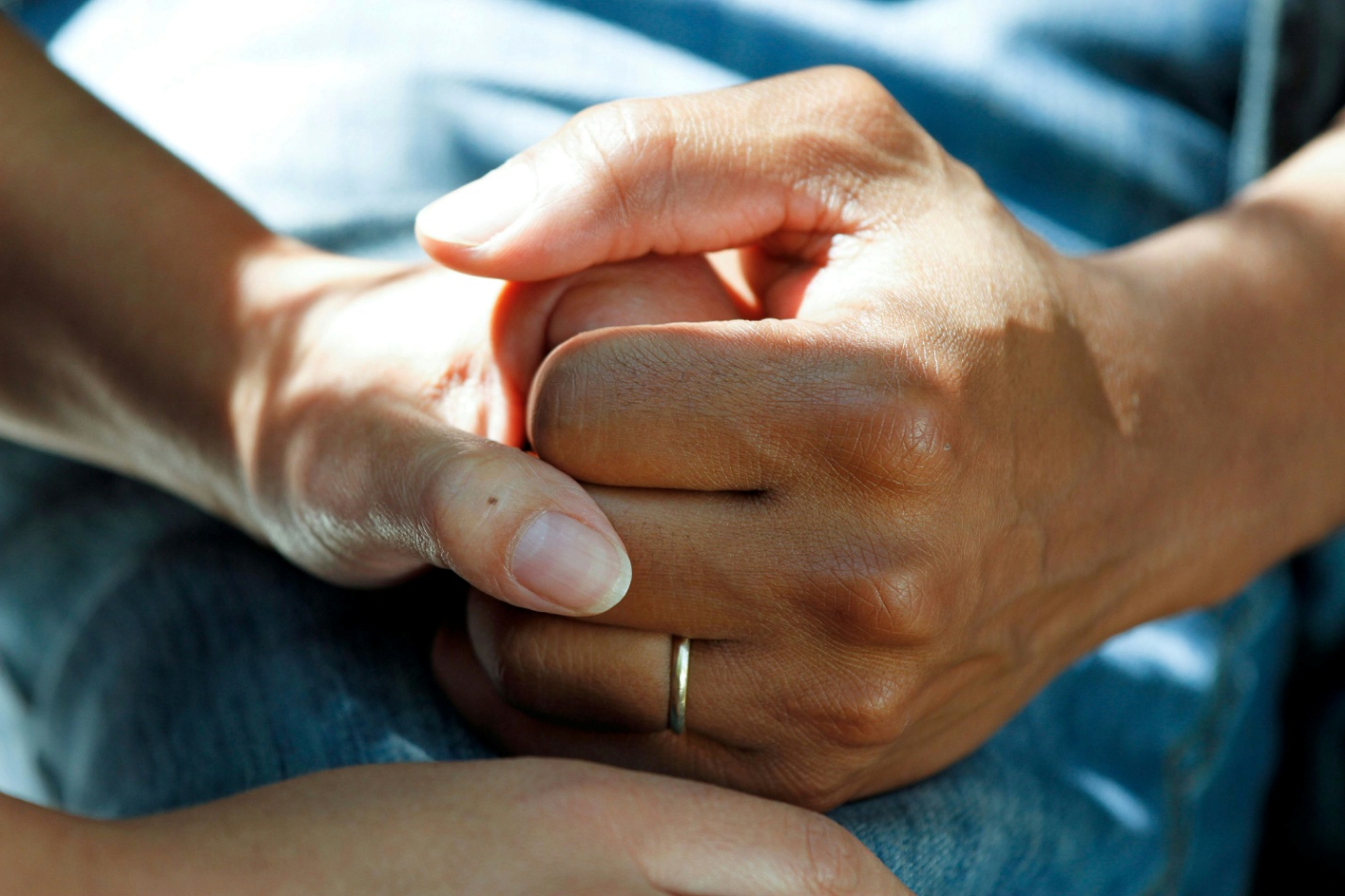 A person in a hospital gown holding hands