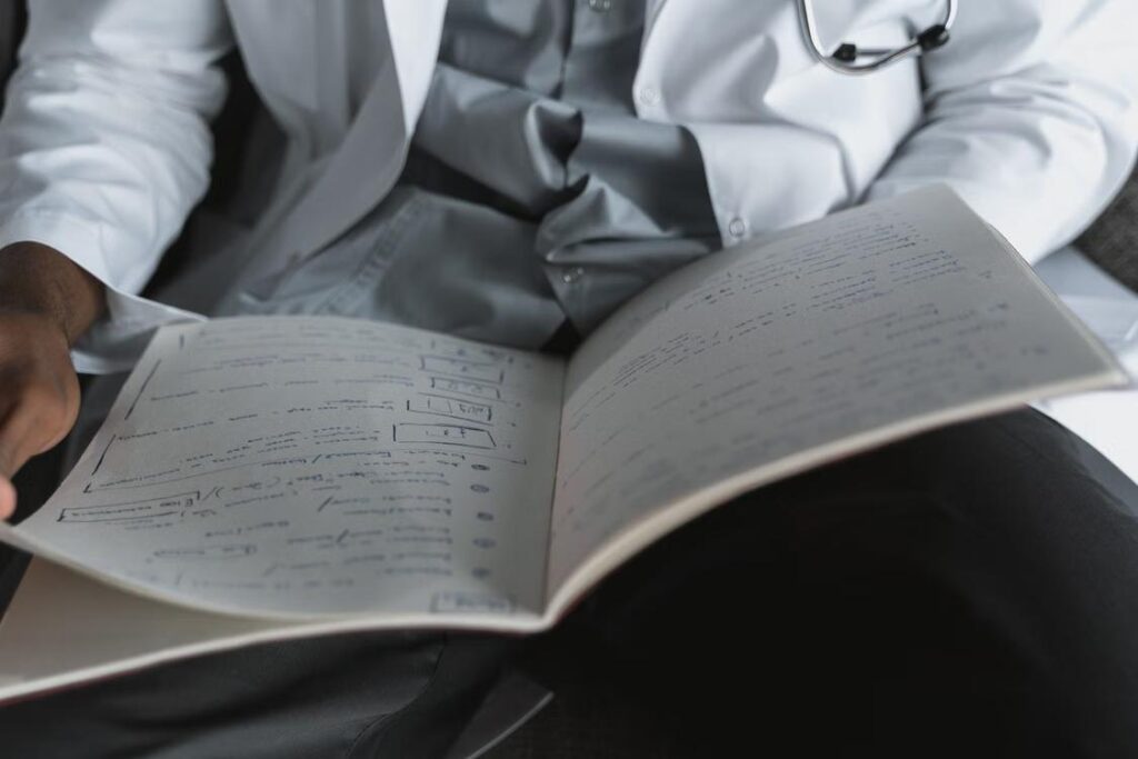 A person working on their notebook with a doctor’s note.