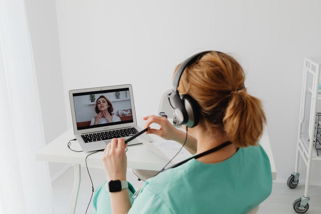 A person working on a computer with their online physician.