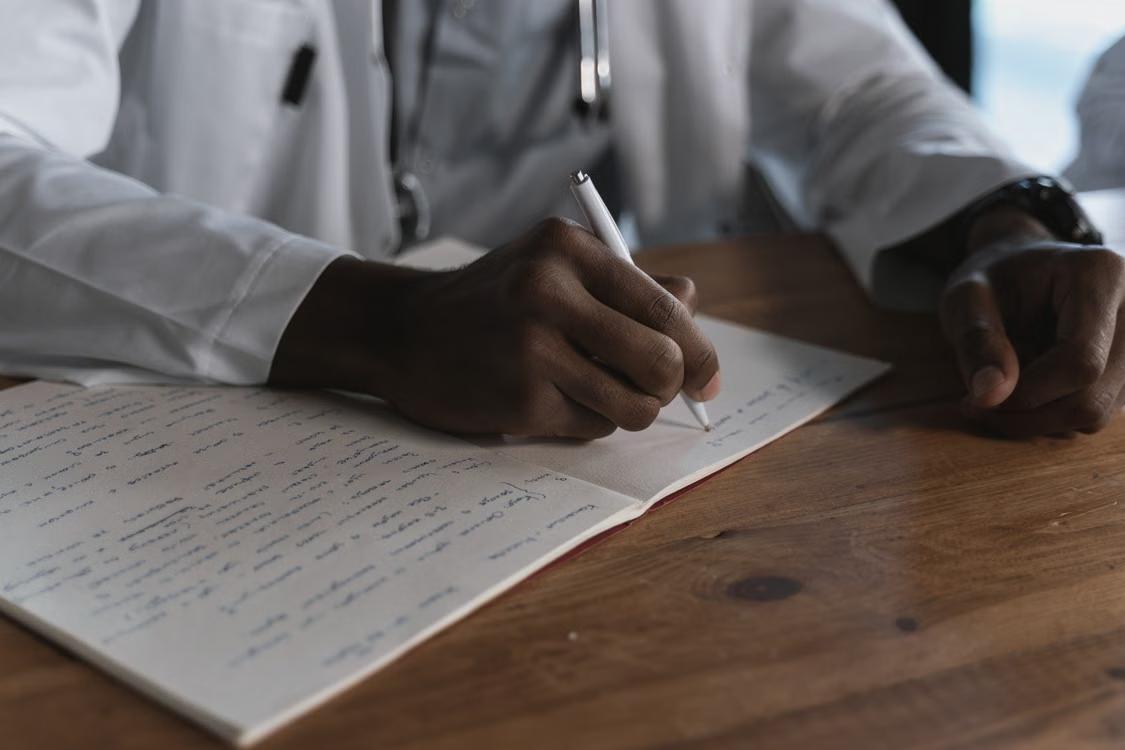 A person writing a note on a piece of paper.